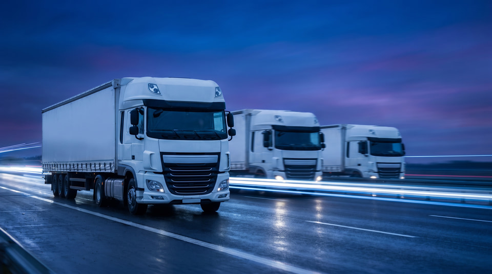 Comboi de camions a l'autopista, a l'hora blava